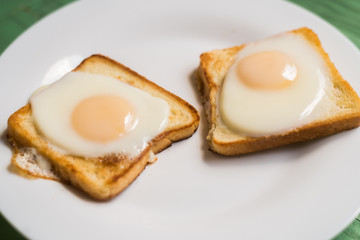 Toast with fried egg on a white plate. Sandwich with chicken egg. Snack, breakfast.