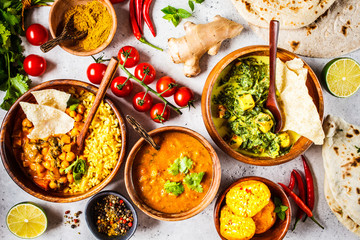 Food traditional Indian cuisine. Dal, palak paneer, curry, rice, chapati, chutney in wooden bowls on white background.