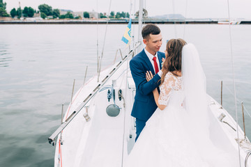 Wedding couple on the yacht, lovers posing on the yacht