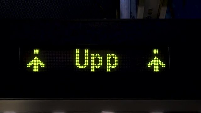 Up sign. Electronic board with arrows in the subway. Animations of yellow arrows going up on a LED panel