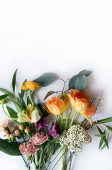 Vertical image of fresh cut flowers and greenery on a white background with copy space