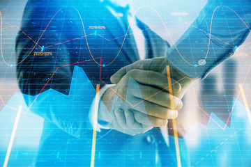 Double exposure of financial graph on cityscape background with two businessman handshake. Concept of stock market deal
