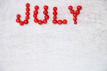 Word made up of natural fresh organic berries of red currant on a white wooden background. Top view