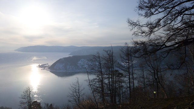 View of the source of the Angara river from lake Baikal in the Irkutsk region. The village of Listvyanka in Siberia, Russia. Sunset over the lake - mountains, forest, lake