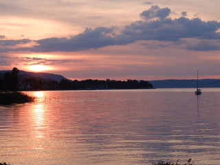 Soleil couchant le soir sur l'eau d'un lac avec bateau