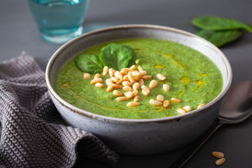 green creamy cauliflower spinach soup on gray background