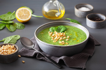 green creamy cauliflower spinach soup on gray background