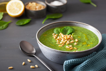 green creamy cauliflower spinach soup on gray background