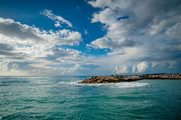 The seeming serenity of the sun, blue sky, light clouds and the turquoise sea gradually captures the bad weather.