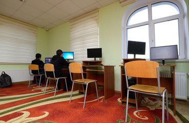 At the computer room. Boys sitting in front of monitors of computers