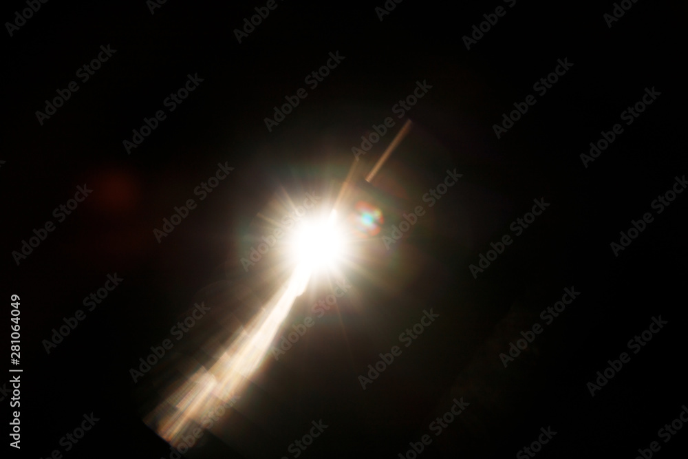 Poster Lens Flare. Light over black background. Easy to add overlay or screen filter over photos. Abstract sun burst with digital lens flare background. Gleams rounded and hexagonal shapes, rainbow halo.