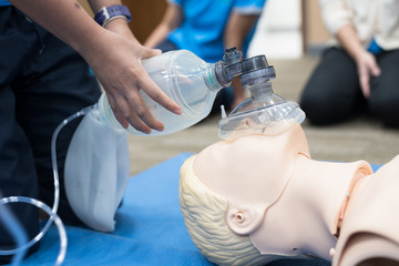 Demonstrating CPR (Cardiopulmonary resuscitation) training medical procedure on CPR doll in the...