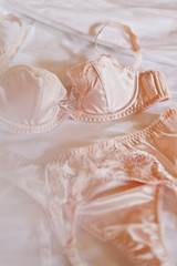 Close-up beige lingerie lying on the bed, the concept of the wedding night, selective focus