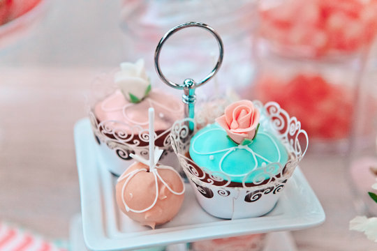 Close-up of multi colored cupcakes on many tier pedestals ready for a picnic, buffet or an away wedding ceremony, selective focus