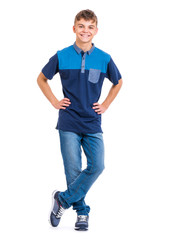 Full length portrait of young caucasian teen boy. Funny teenager looking at camera and smiling. Handsome child - hands on waist, isolated on white background.