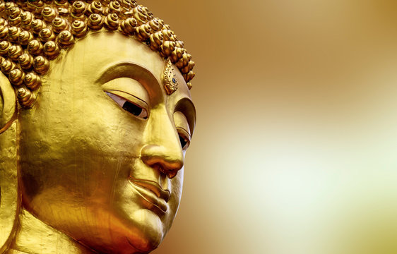 Closeup Face of Statue big buddha in Asia Thailand. golden Colorful on yellow blur background