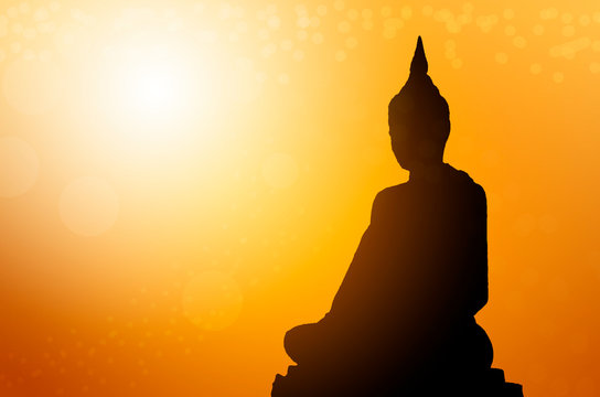 Silhouette buddha statues on blur sunset background. Concept buddha isolated on orange blurred background