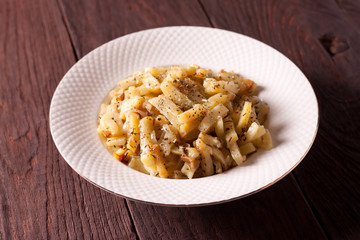 Fried potatoes with onions and seasonings on a white plate