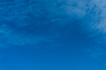 Bright blue sky and small cloud background