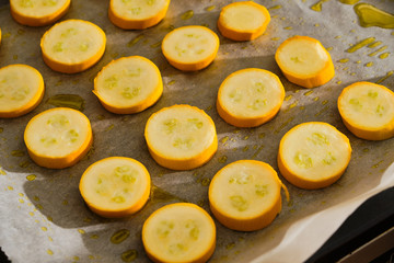 Sliced yellow zucchini on baking paper