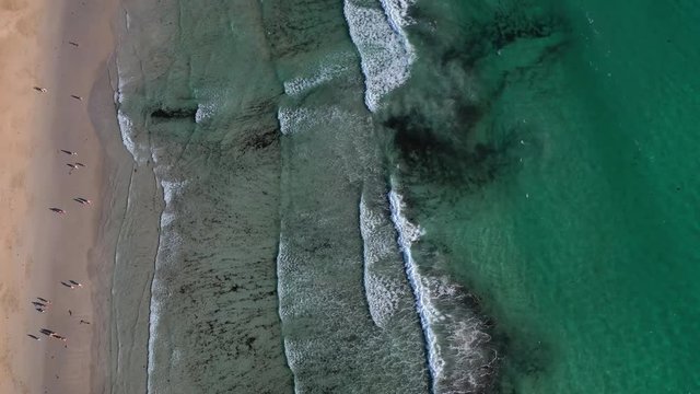 ocean waves sandy beach with people bathing in the water view from drone Lanzada beach Galicia Spain 4k video