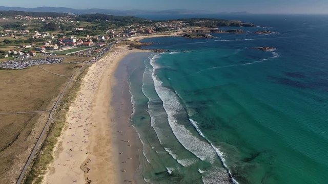 ocean waves sandy beach with people bathing in the water view from drone Lanzada beach Galicia Spain 4k video