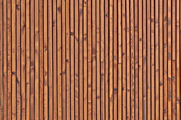 The texture of the surface of the wooden planks. Background of the ceiling cladding planks. Smooth boards with knots.