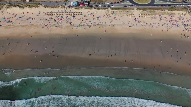 ocean waves sandy beach with people bathing in the water view from drone Lanzada beach Galicia Spain 4k video