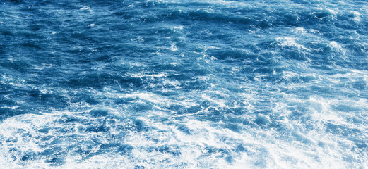 View of the blue sea or ocean with foam and waves background.
