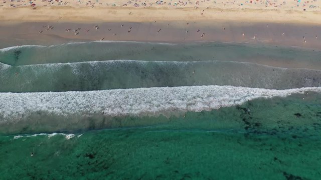 ocean waves sandy beach with people bathing in the water view from drone Lanzada beach Galicia Spain 4k video