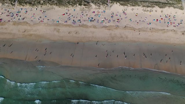 ocean waves sandy beach with people bathing in the water view from drone Lanzada beach Galicia Spain 4k video