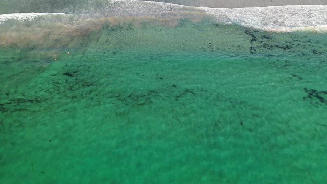 ocean waves sandy beach with people bathing in the water view from drone Lanzada beach Galicia Spain 4k video
