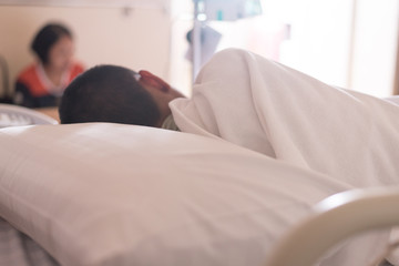 Close up back patient Asian young boy sleeping on bed and blurry set iv fluid intravenous drop...