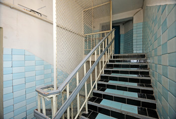 Part of prison hallway, bars, stairs, doors of the detention facility 