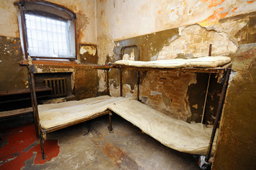 In the Ukrainian prison. Part of an old cell with bunks and mattresses, bars on a window