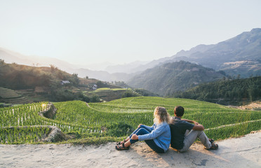 Young Caucasian couple overlooking rice terraces of Sapa at sunset in Lao Cai region of Vietnam