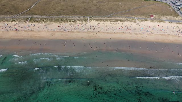 ocean waves sandy beach with people bathing in the water view from drone Lanzada beach Galicia Spain 4k video