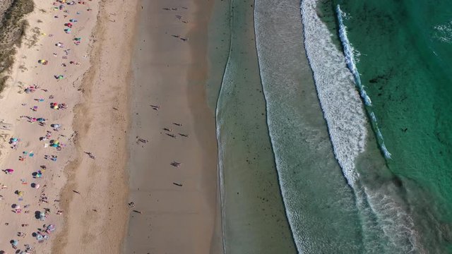 ocean waves sandy beach with people bathing in the water view from drone Lanzada beach Galicia Spain 4k video
