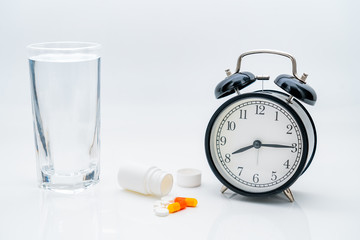 Pills, capsules, bottles and alarm clock