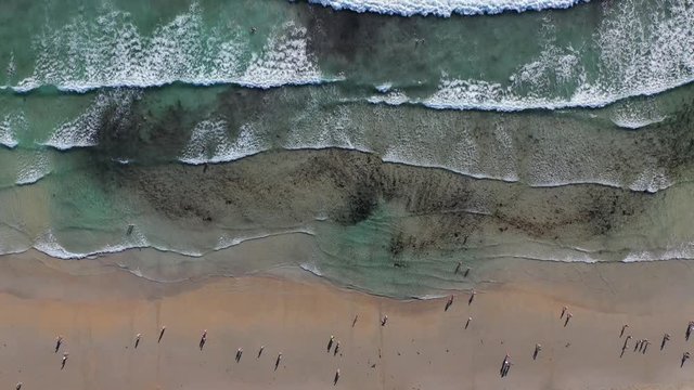 ocean waves sandy beach with people bathing in the water view from drone Lanzada beach Galicia Spain 4k video