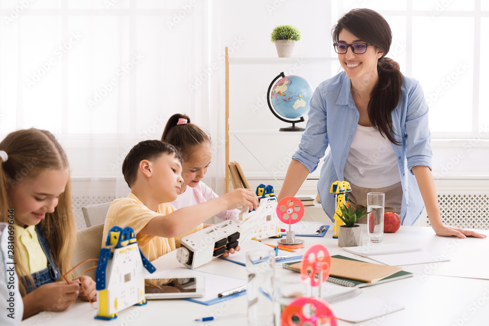 Poster children building robot vehicle with teacher's help