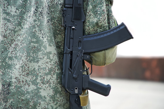 A man with a gun in protective clothing khaki on a white background. Back. Patrol or security. Federal Firearms License