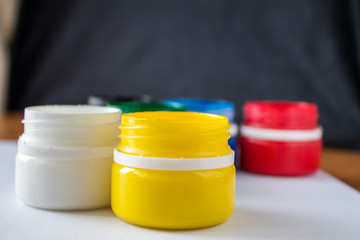 Paint jars and sketchbook on a wooden table. Learning to draw. Paints gouache