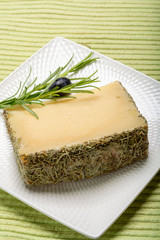 Cheese collection, one piece of Spanish manchego sheep cheese with rosemary herb