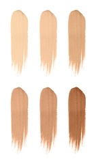 Set with smears of different foundations on white background