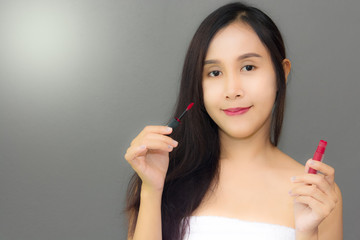 Young women use lipstick apply to her lips already with smmile