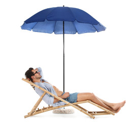 Young man on sun lounger under umbrella against white background. Beach accessories