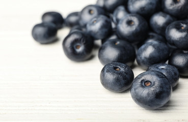 Fresh acai berries on white wooden table, closeup view. Space for text