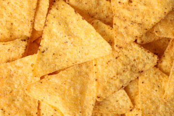 Tasty Mexican nachos chips as background, top view