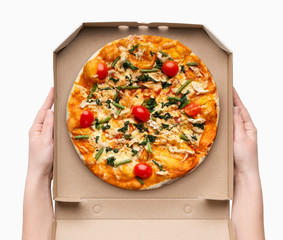 Woman holding delicious pizza in box on white background